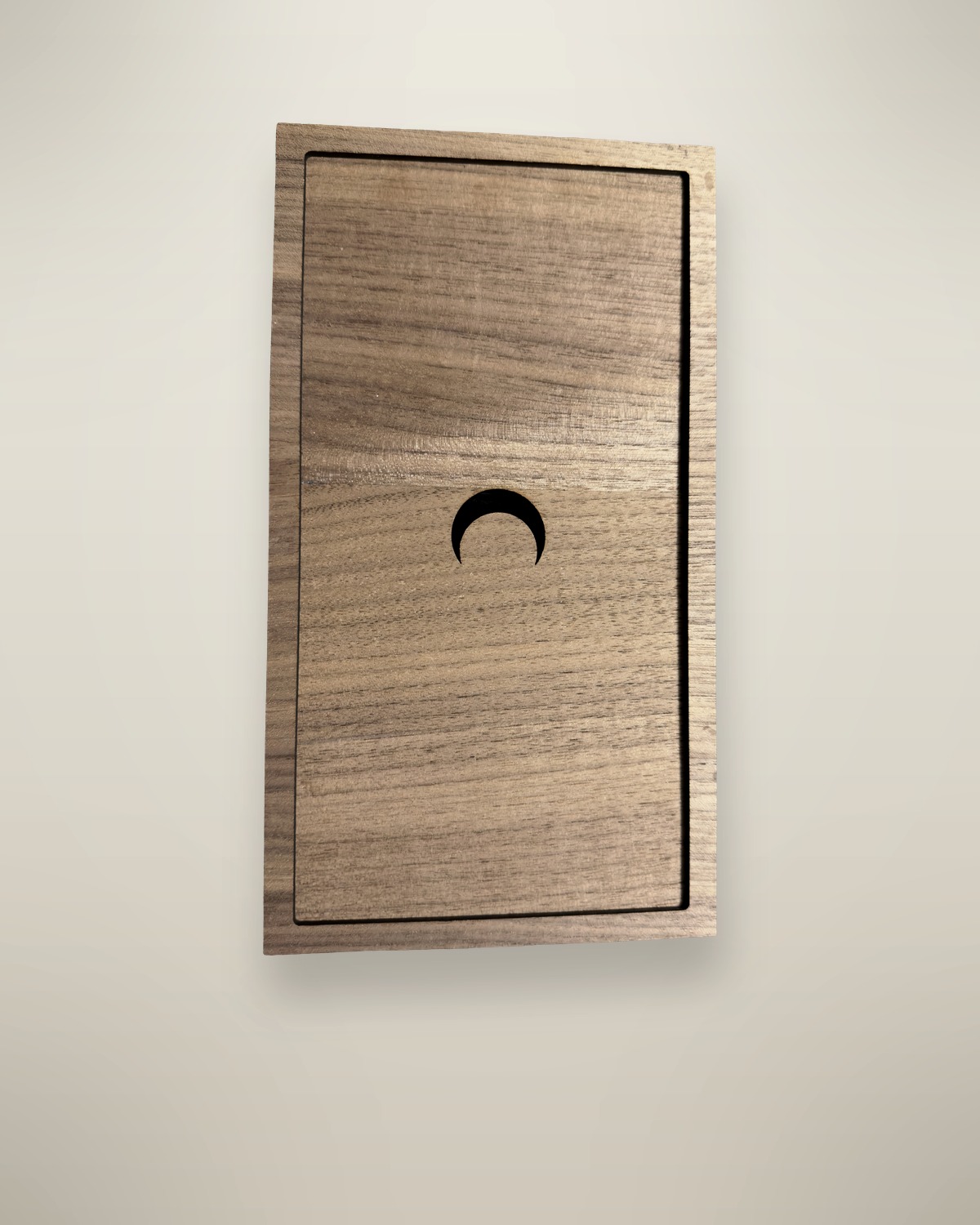 A closed walnut box, the crescent moon cut through the lid.