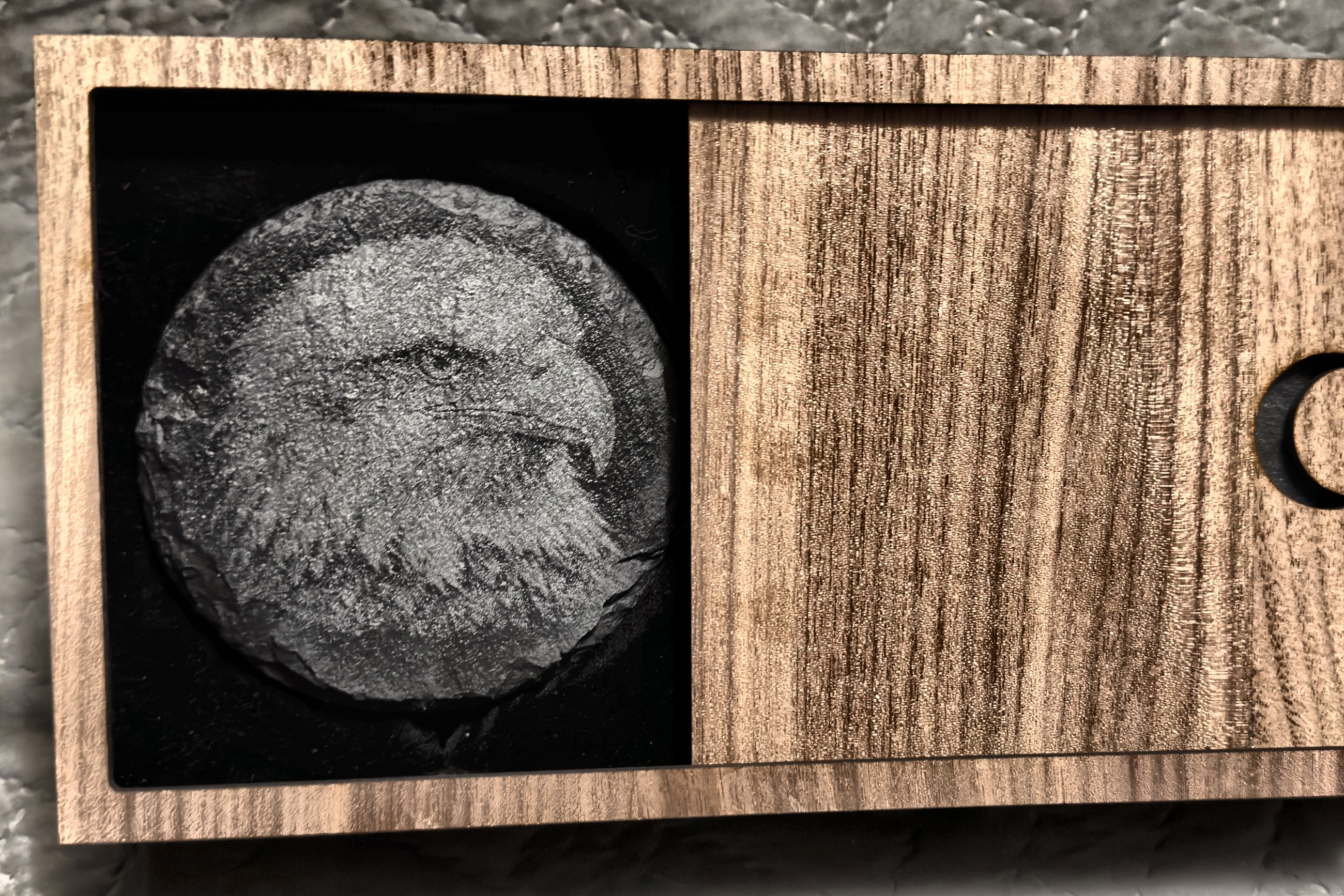 A walnut box slid open to reveal an engraved slate keepsake on black velvet, the crescent cut into the lid.