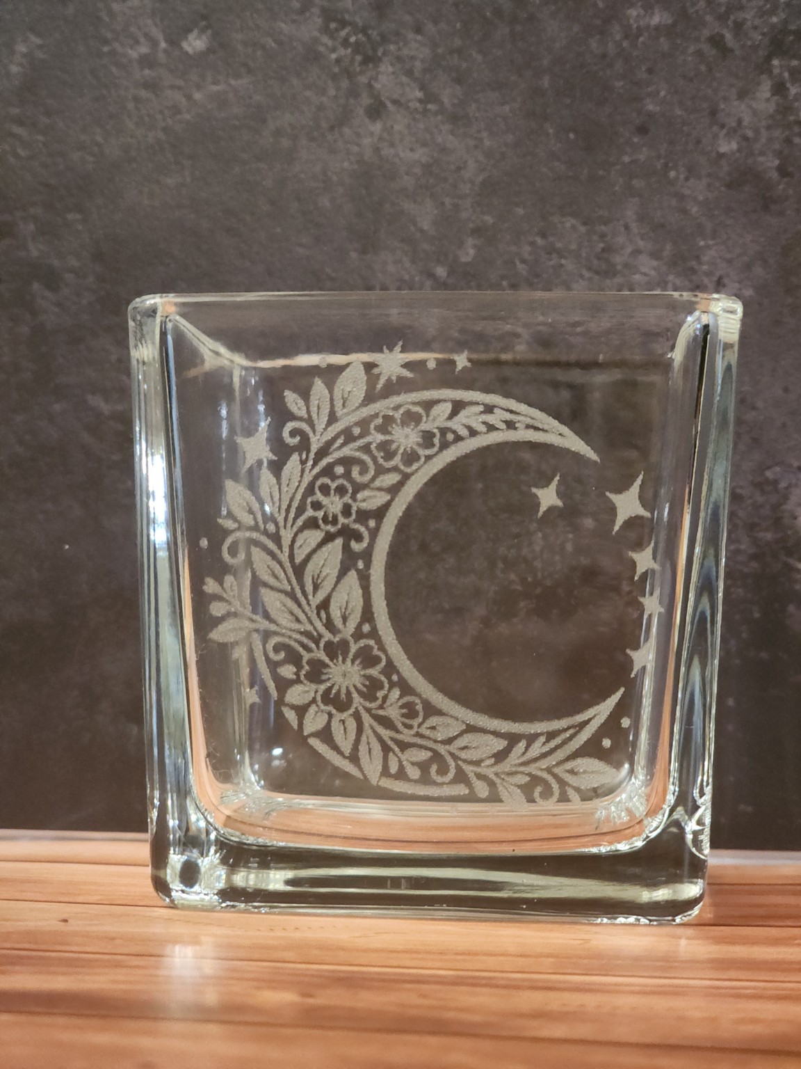 A square glass piece engraved with a floral crescent moon and stars.