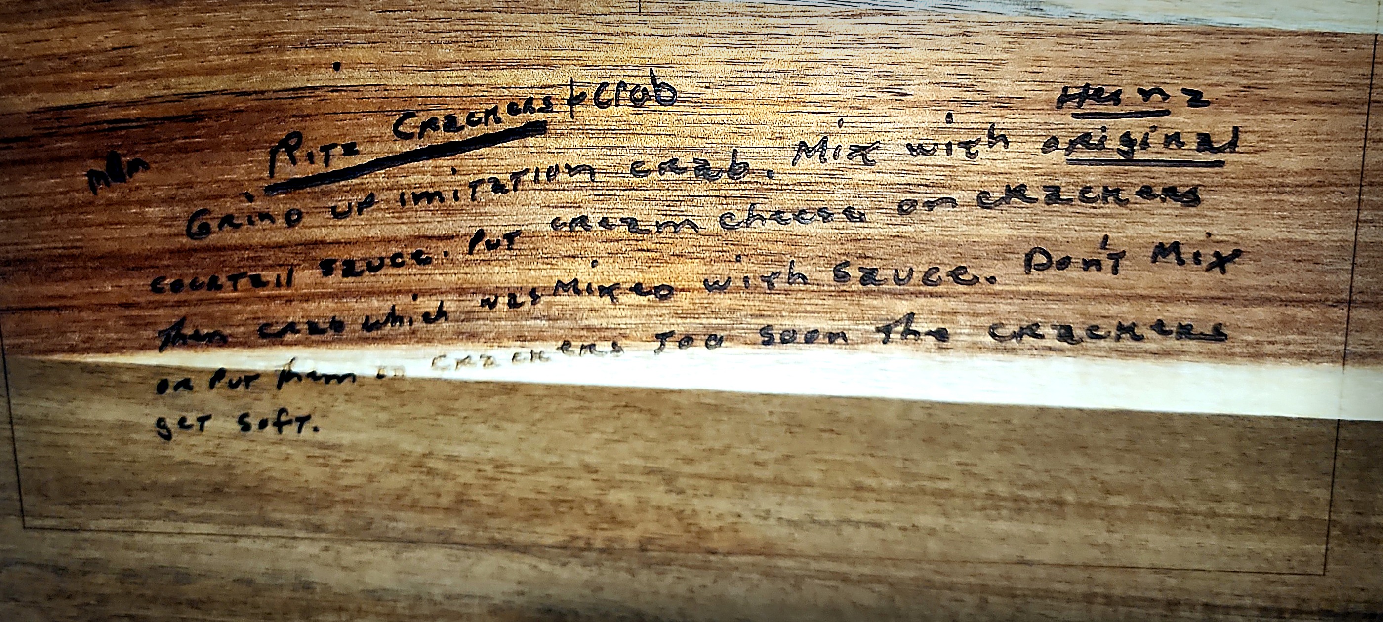 A handwritten recipe engraved into a walnut serving board, in the original hand.