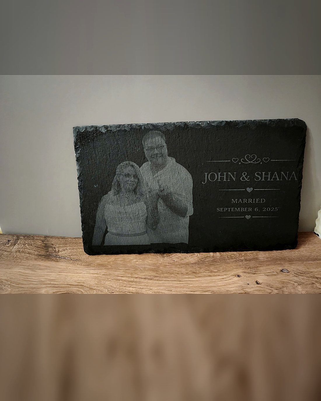 A slate engraved with a couple's photo, their names and wedding date.